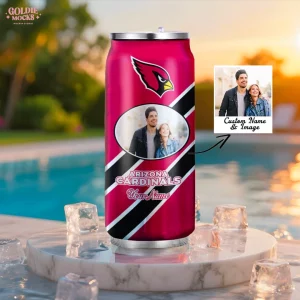 An insulated Arizona Cardinals can tumbler with a custom photo, sitting on a pedestal with ice cubes by a pool, perfect for outdoors.